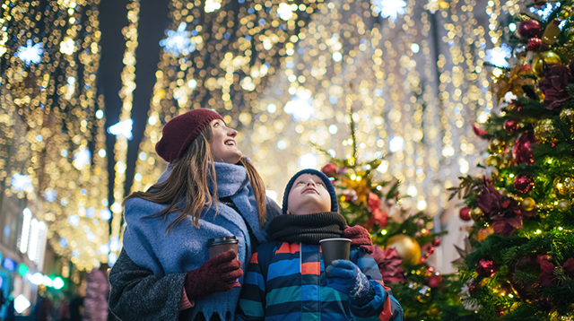 Little boy with his mother buying tera and sweets at a Christmas market